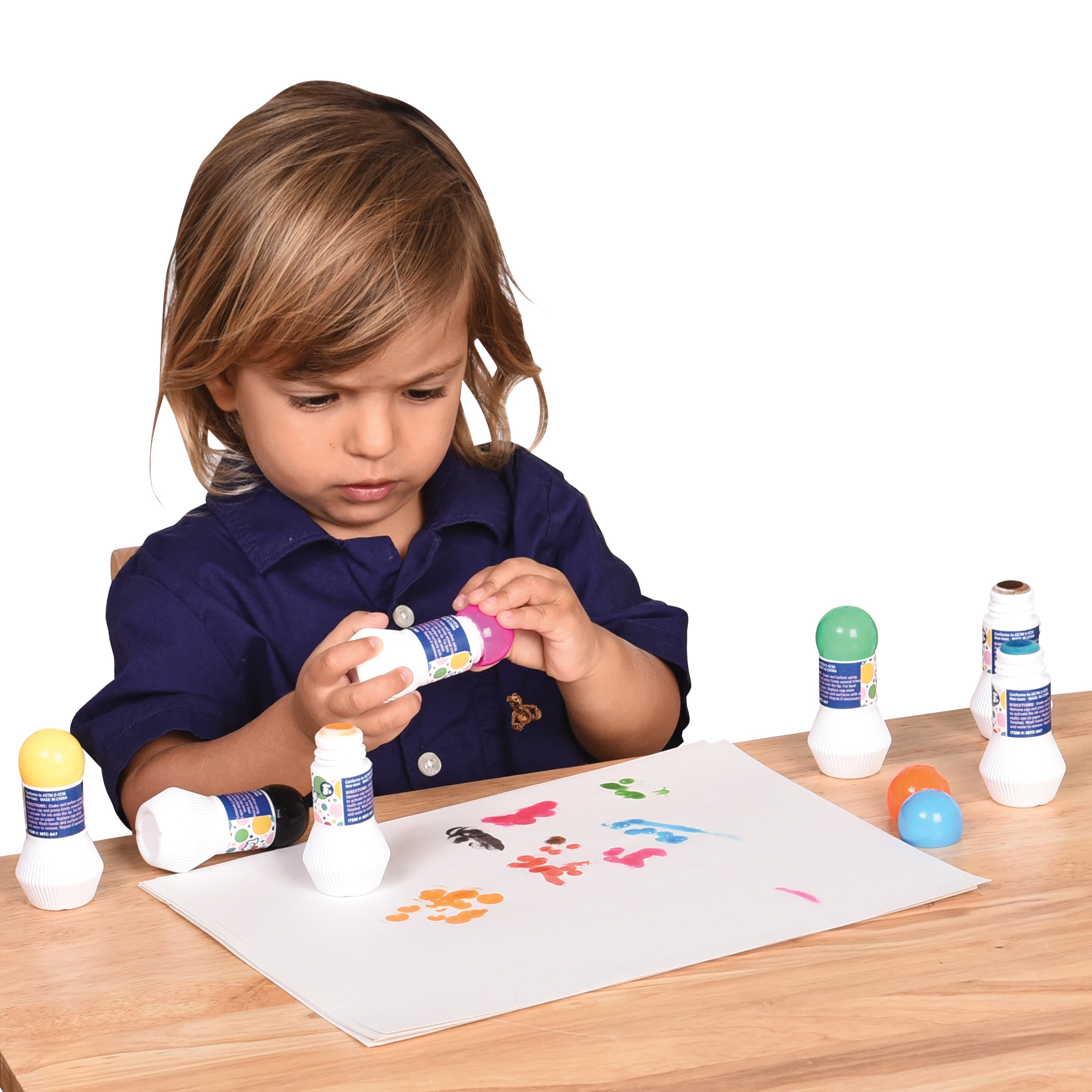 Child playing with colorful bottles on a table