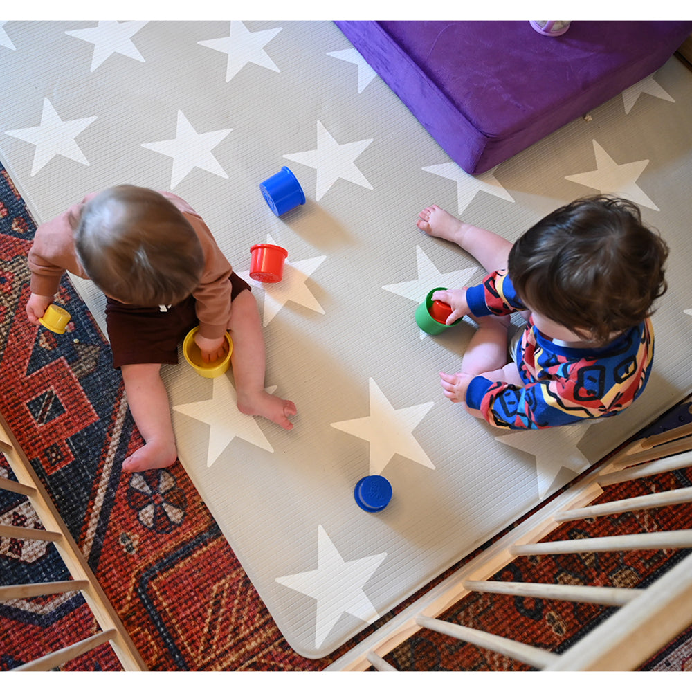 Two Toddlers Playing with Nesting Cups on Floor