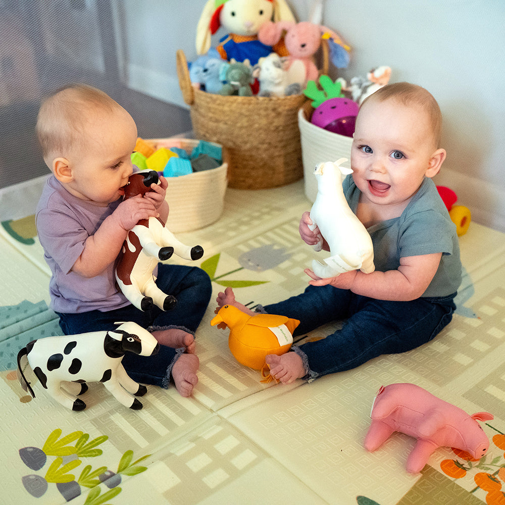 Twins Enjoying Playtime with Soft Vinyl Animals