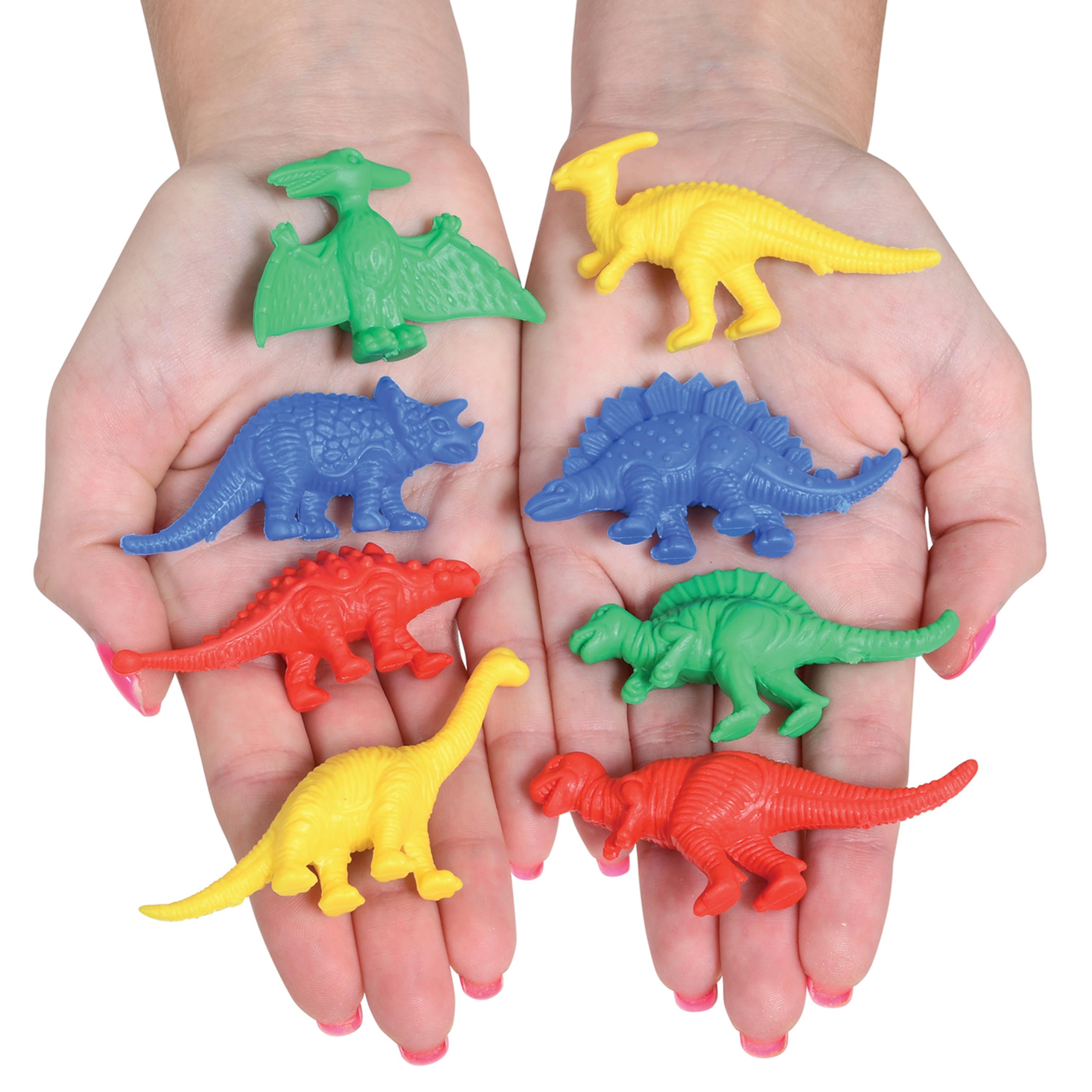 Colorful plastic dinosaur toys held in two hands against a white background