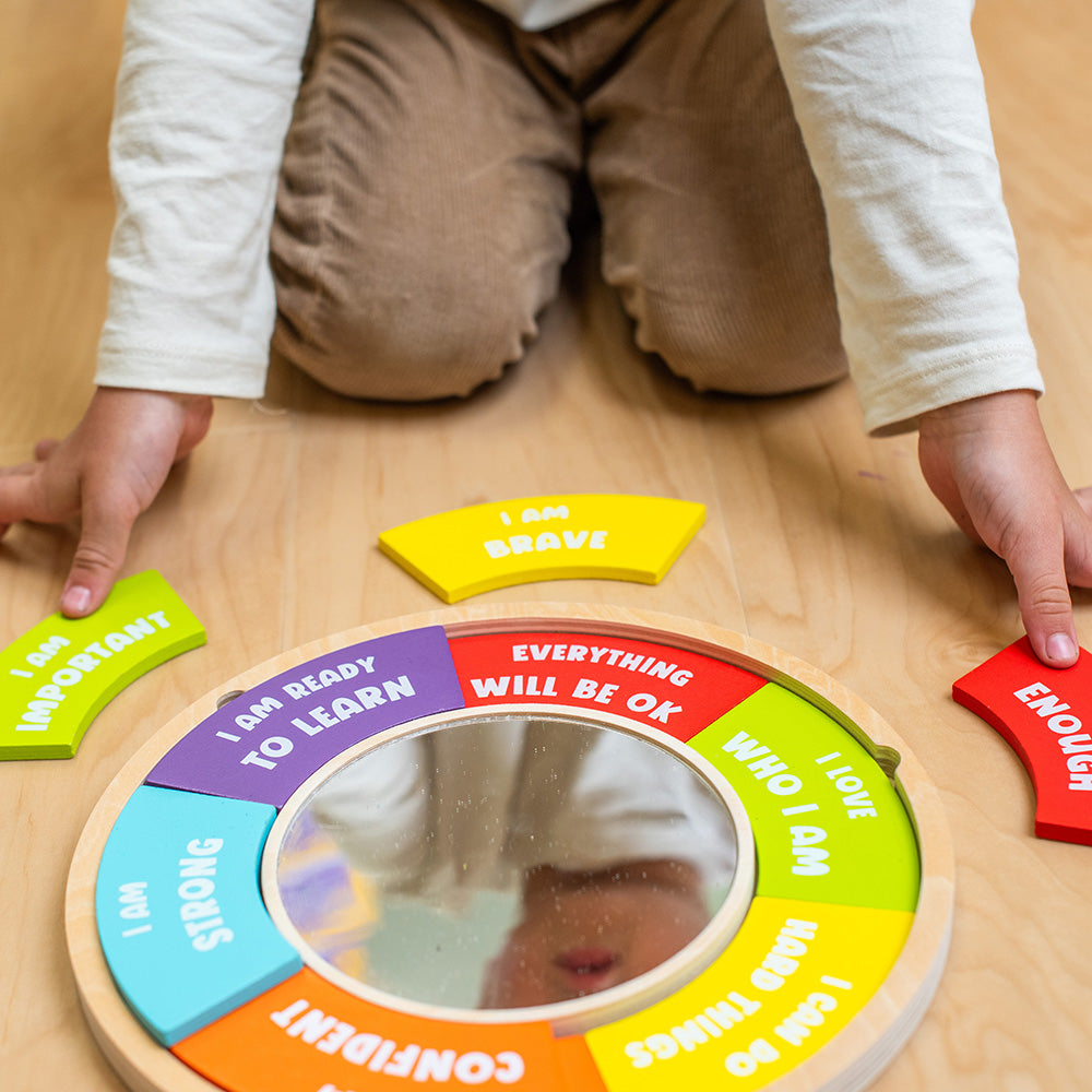 Child playing with a colorful wooden circle toy on a wooden floor