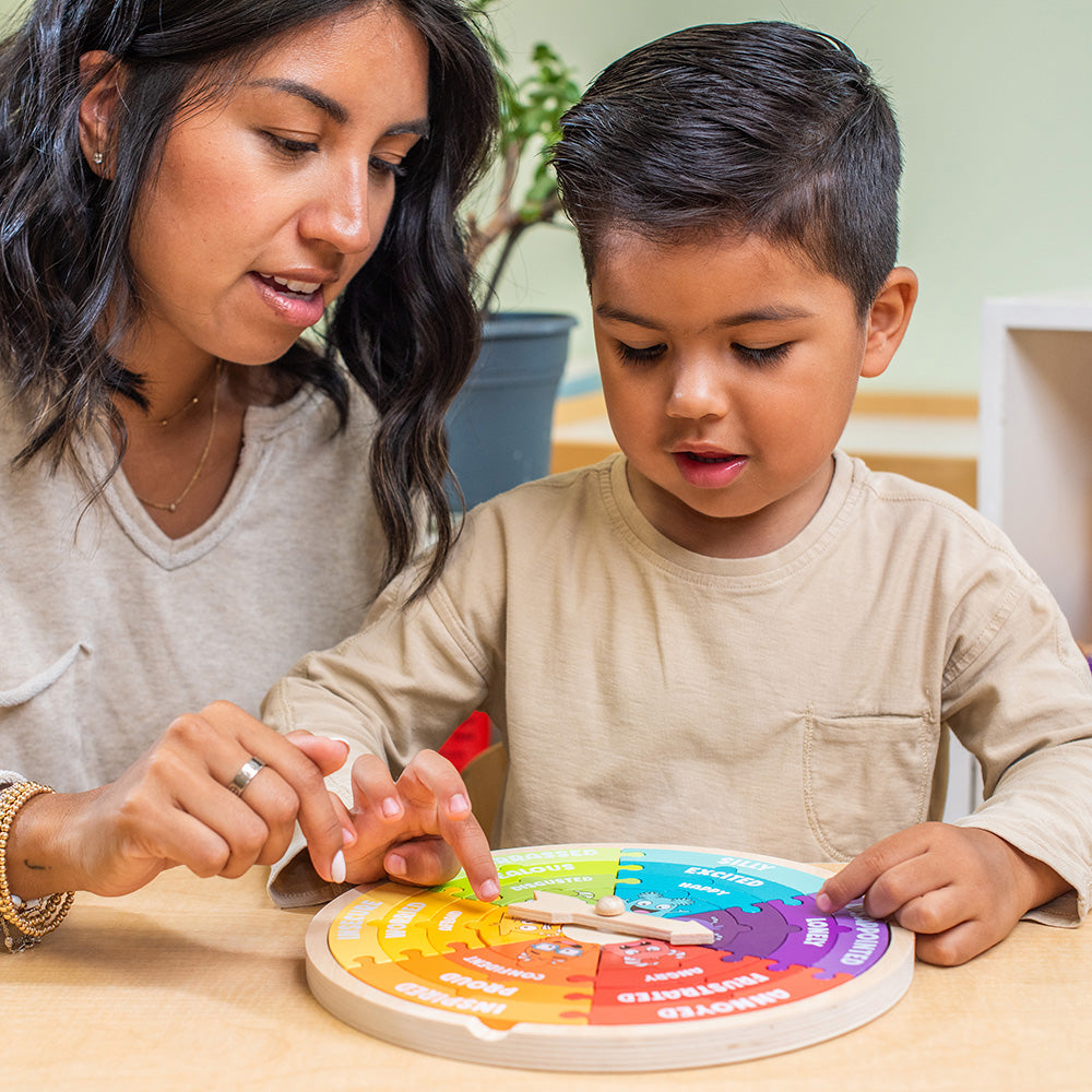 Woman and child playing with a colorful educational toy at a table.