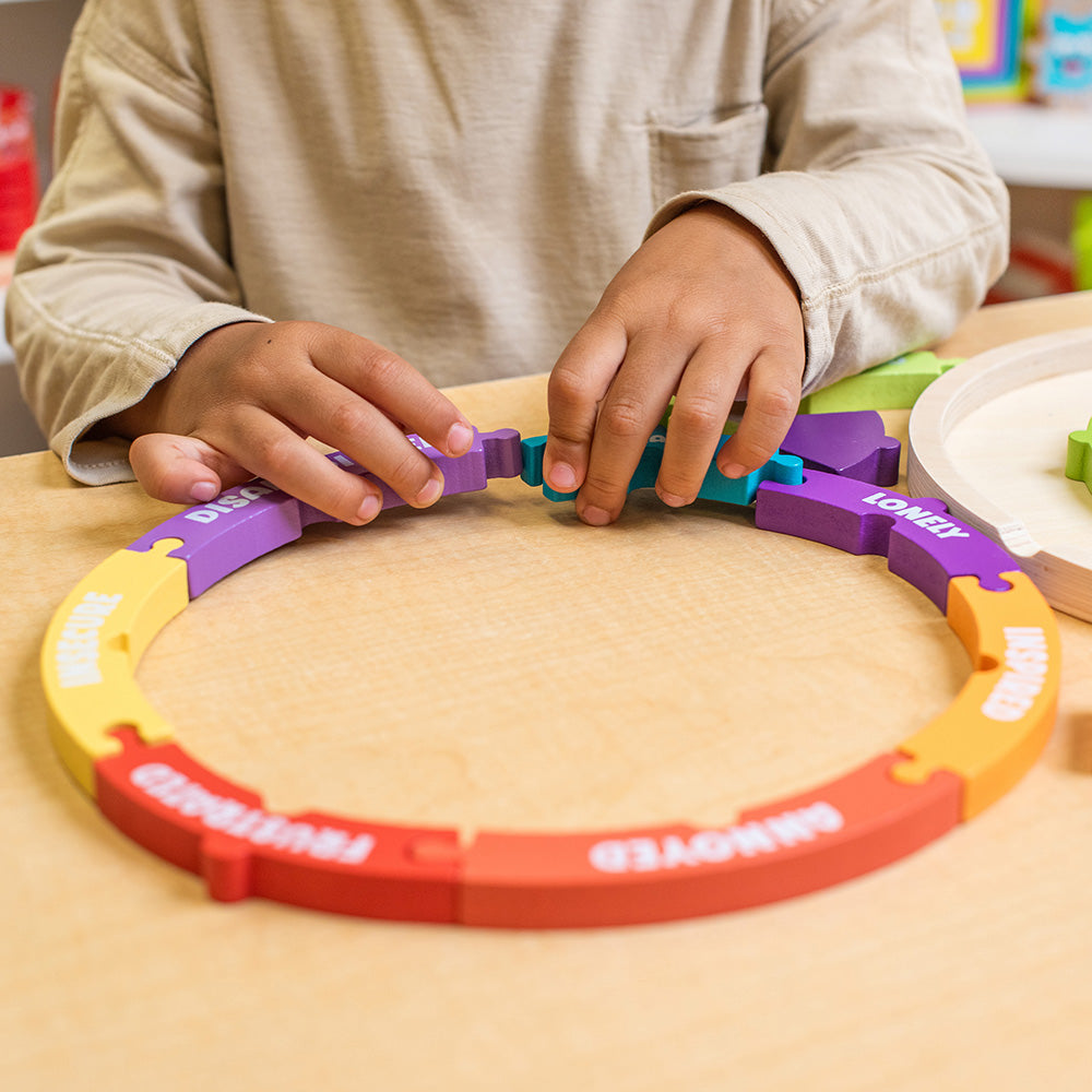 Child playing with colorful interlocking toys on a wooden surface