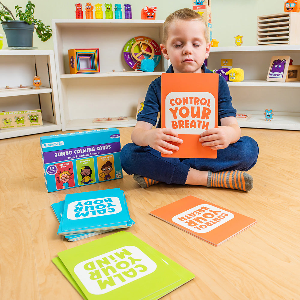Child holding a book titled 'Control Your Breath' in a classroom setting with educational materials around.