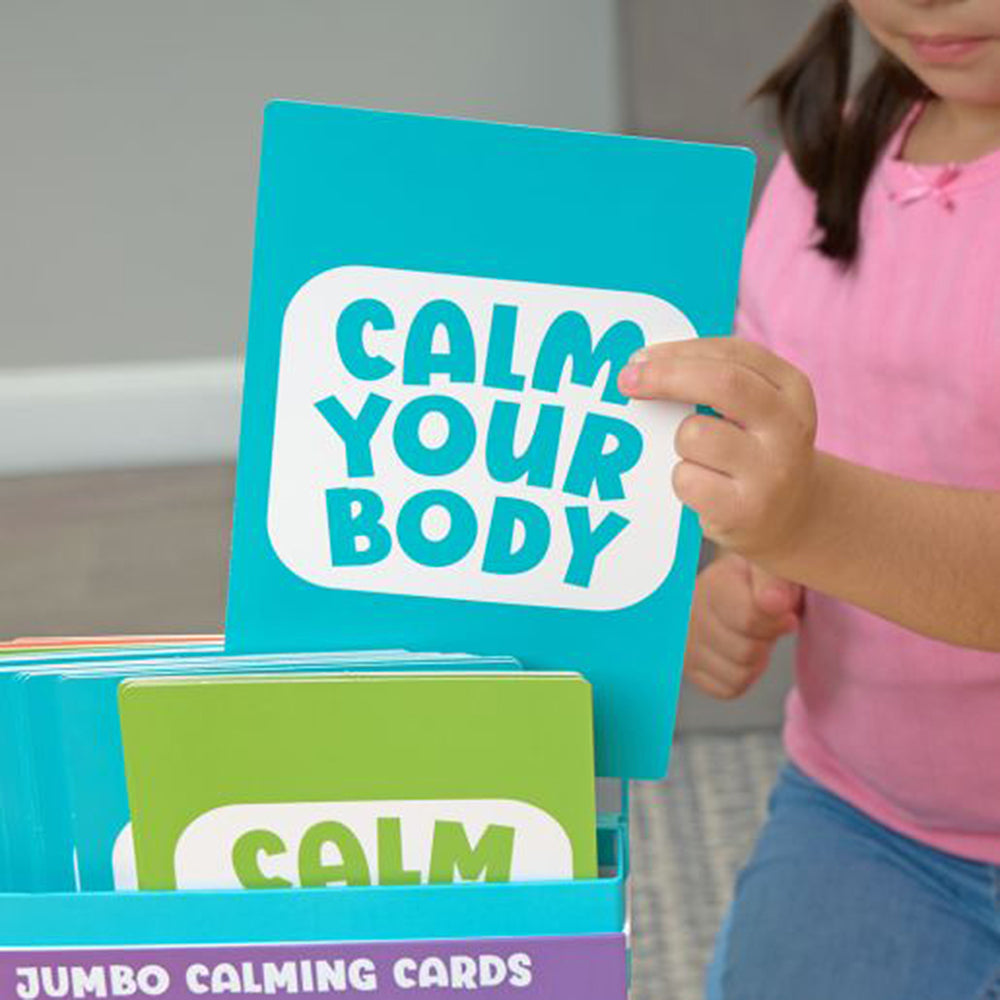 Child holding a 'Calm Your Body' card from a set of calming cards.