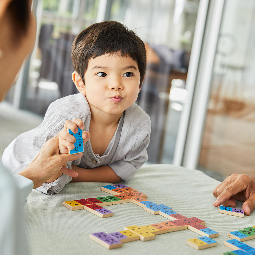 Child playing with colorful wooden blocks on a table