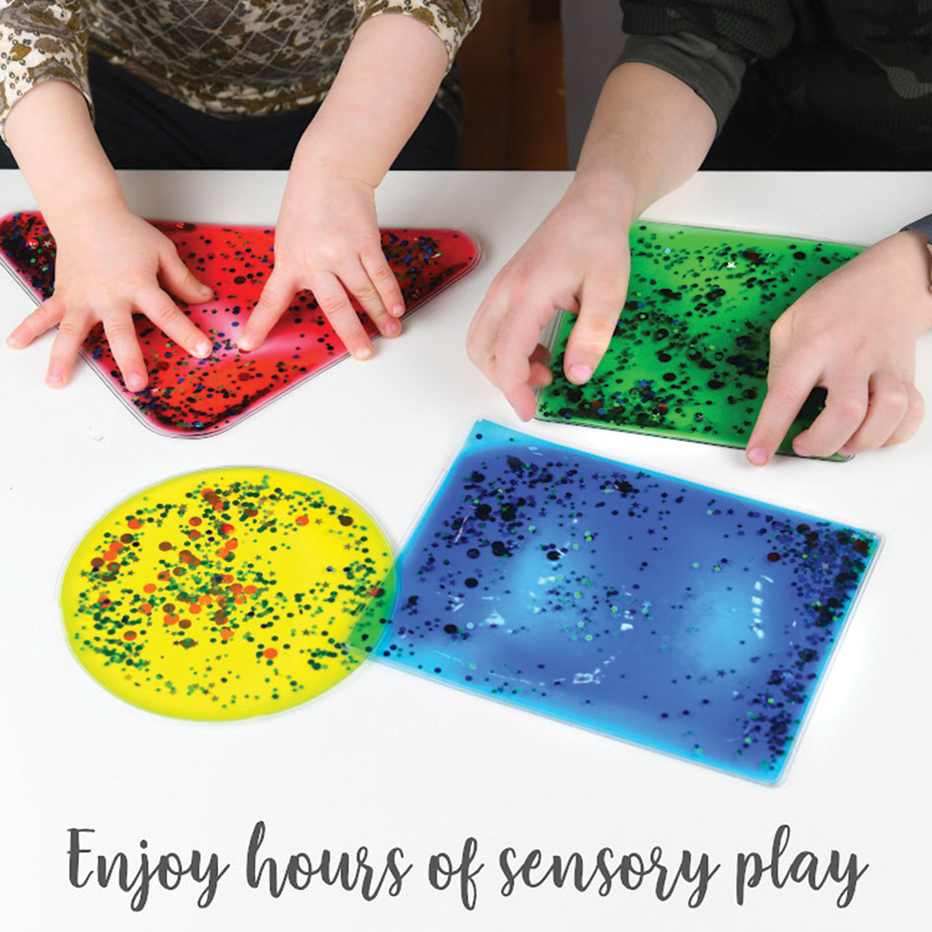 Children playing with colorful splatter shapes on a white surface.