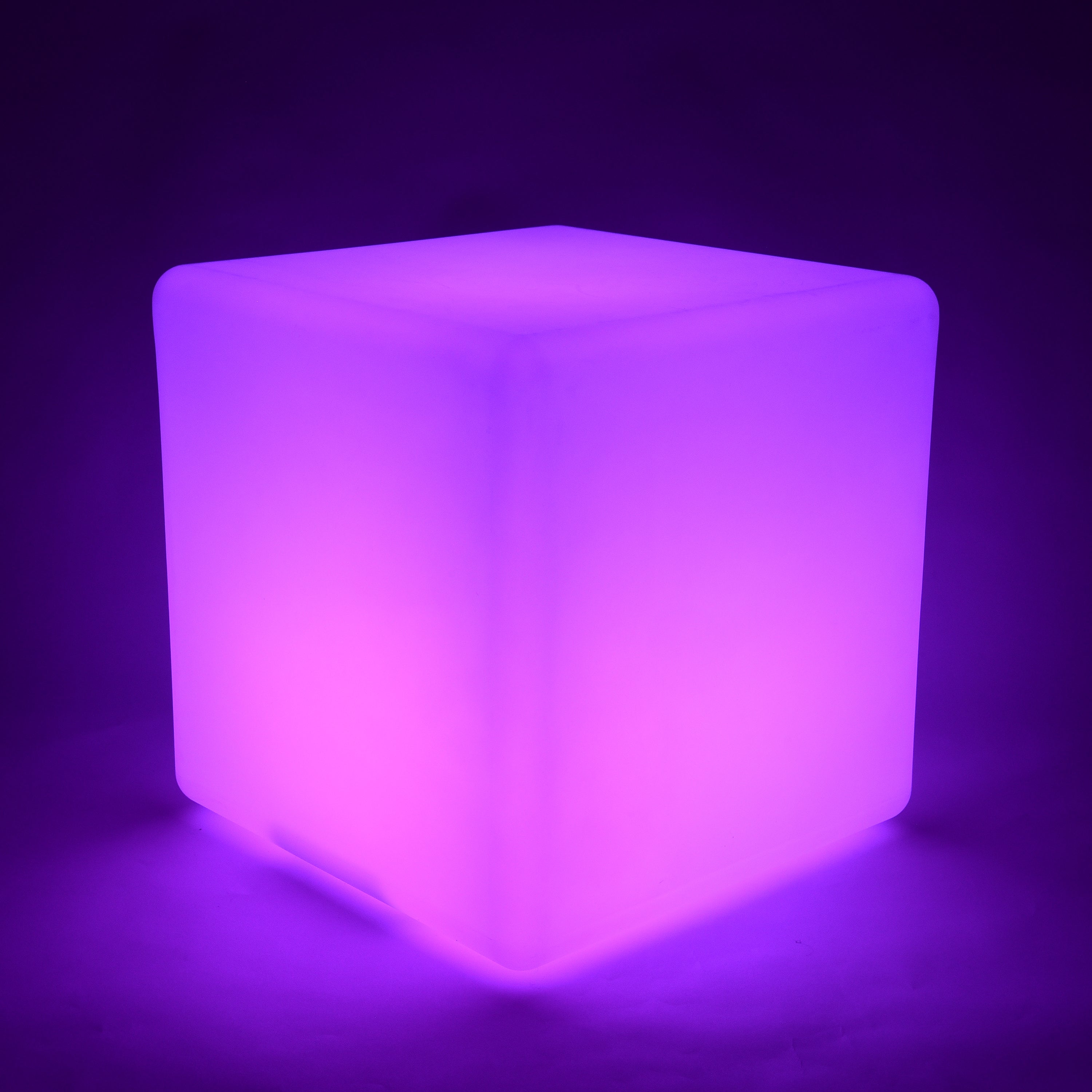 Cube-shaped illuminated object glowing purple on a dark background
