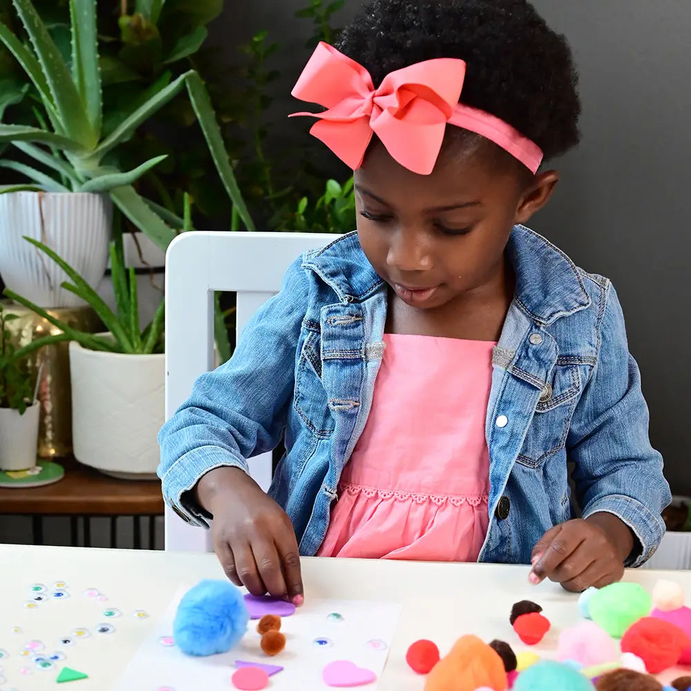 Kid Using Pom Poms in Arts & Crafts