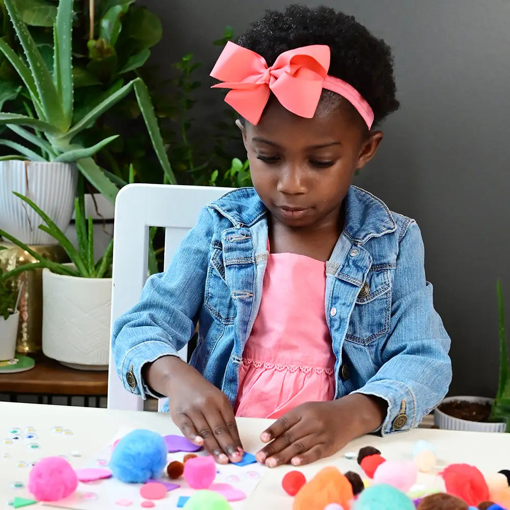 Kid Using Pom Poms in Arts & Crafts