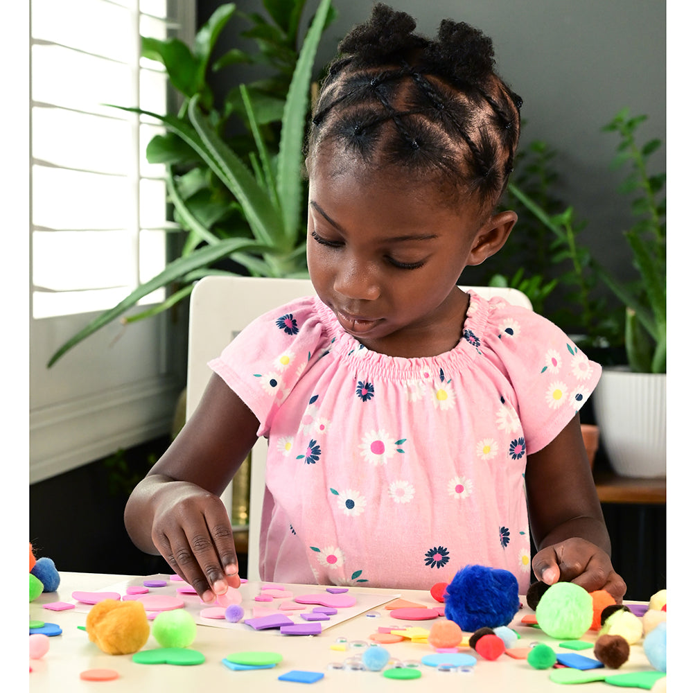 Kid Using Pom Poms in Arts & Crafts