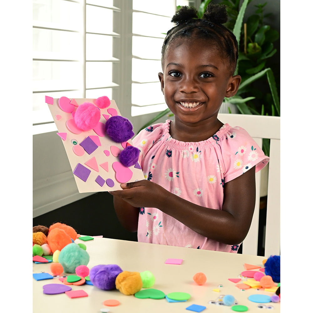 Kid Creating A Picture with Pom Poms and Shapes