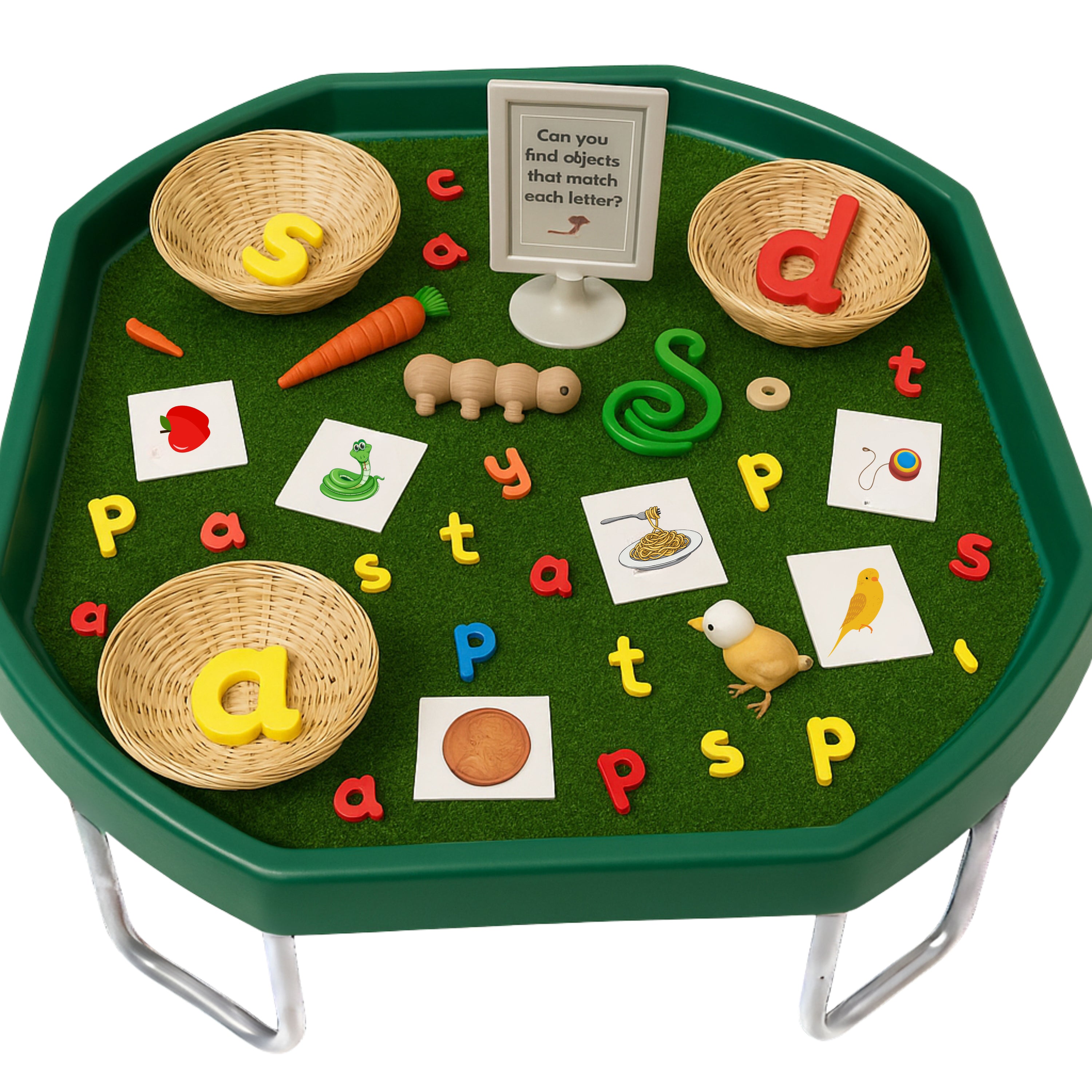 Educational play mat with letters and objects on a green hexagonal table.