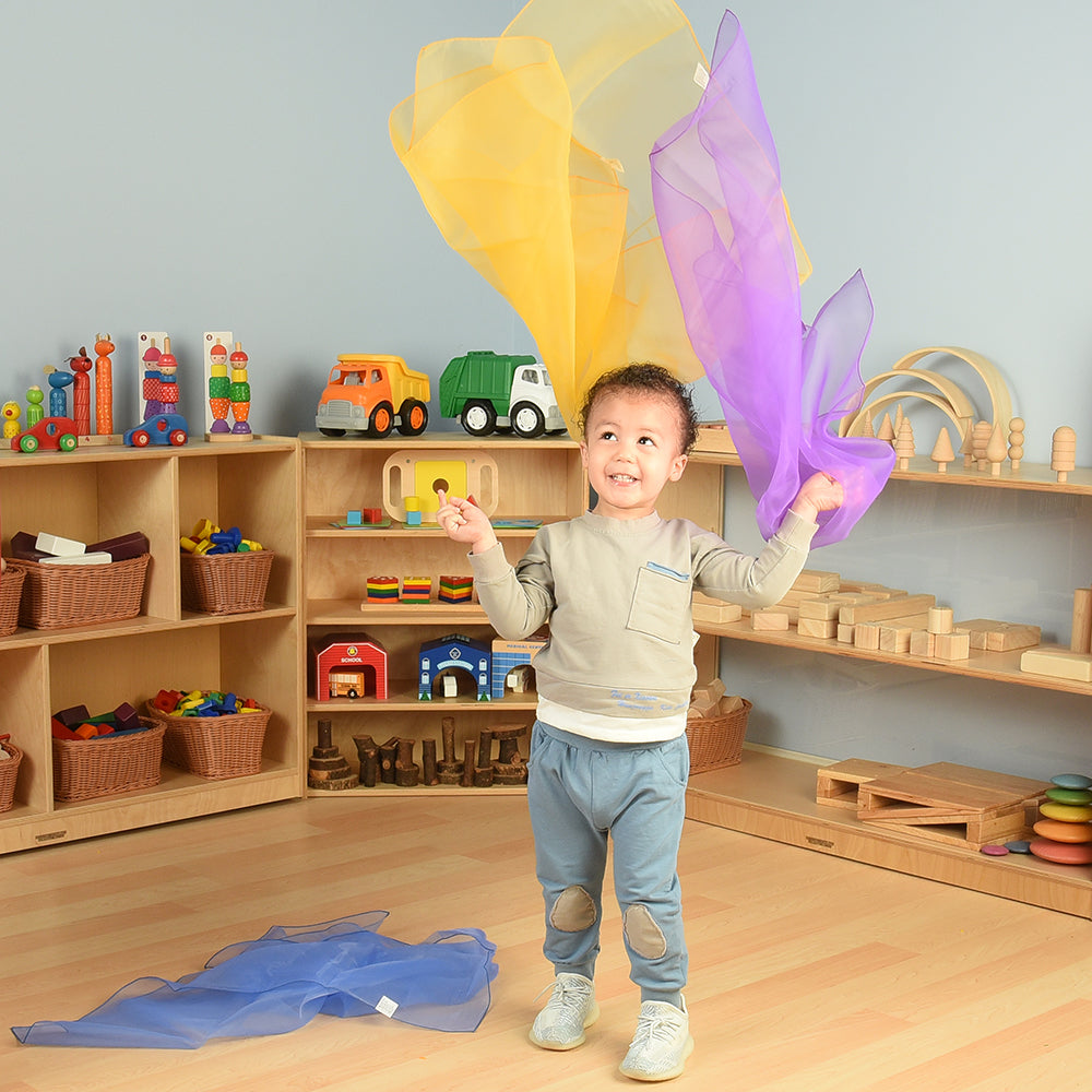 Toddler Tossing Around Rainbow Scarves in the Classroom