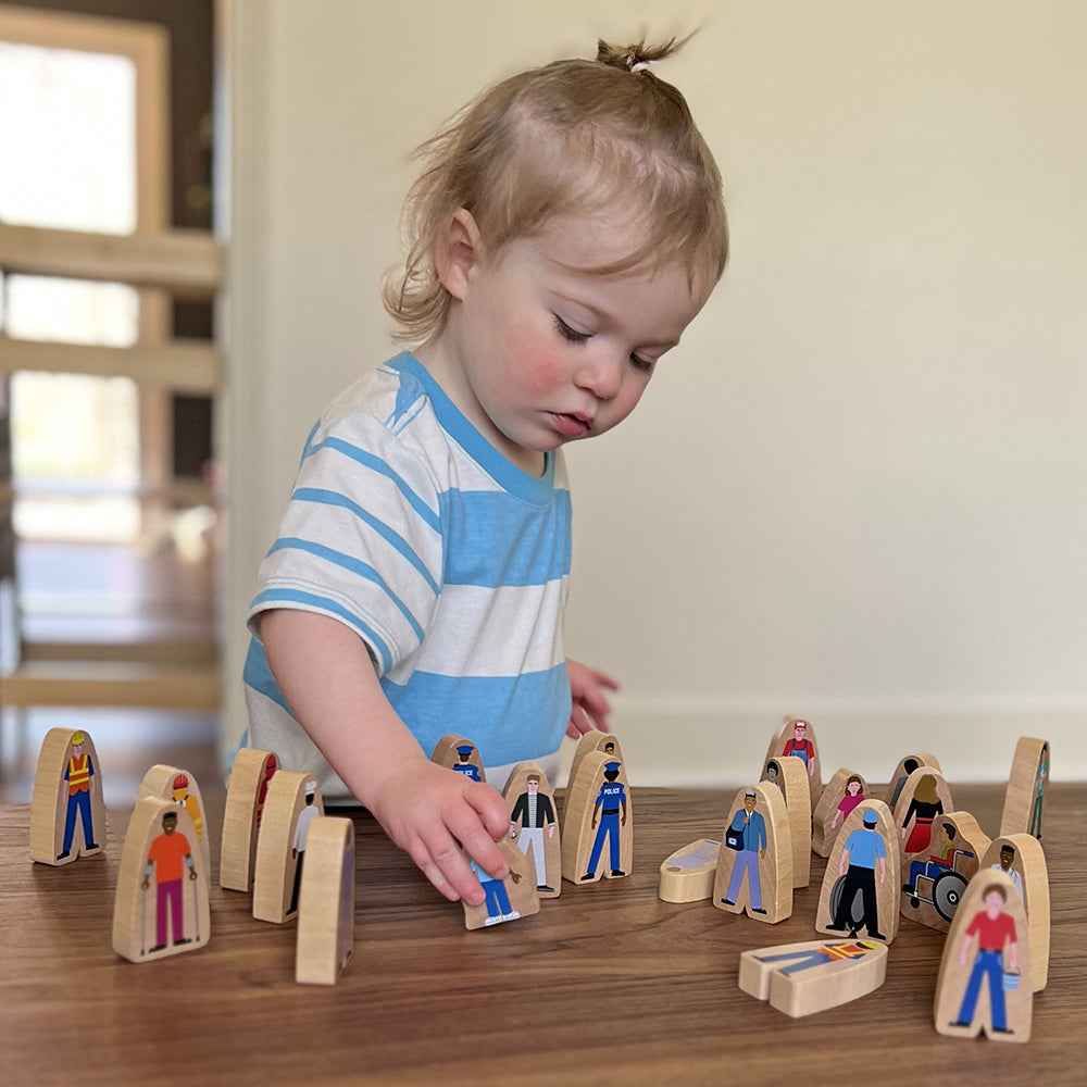 Kid Playing with Diverse Wooden Community Figures