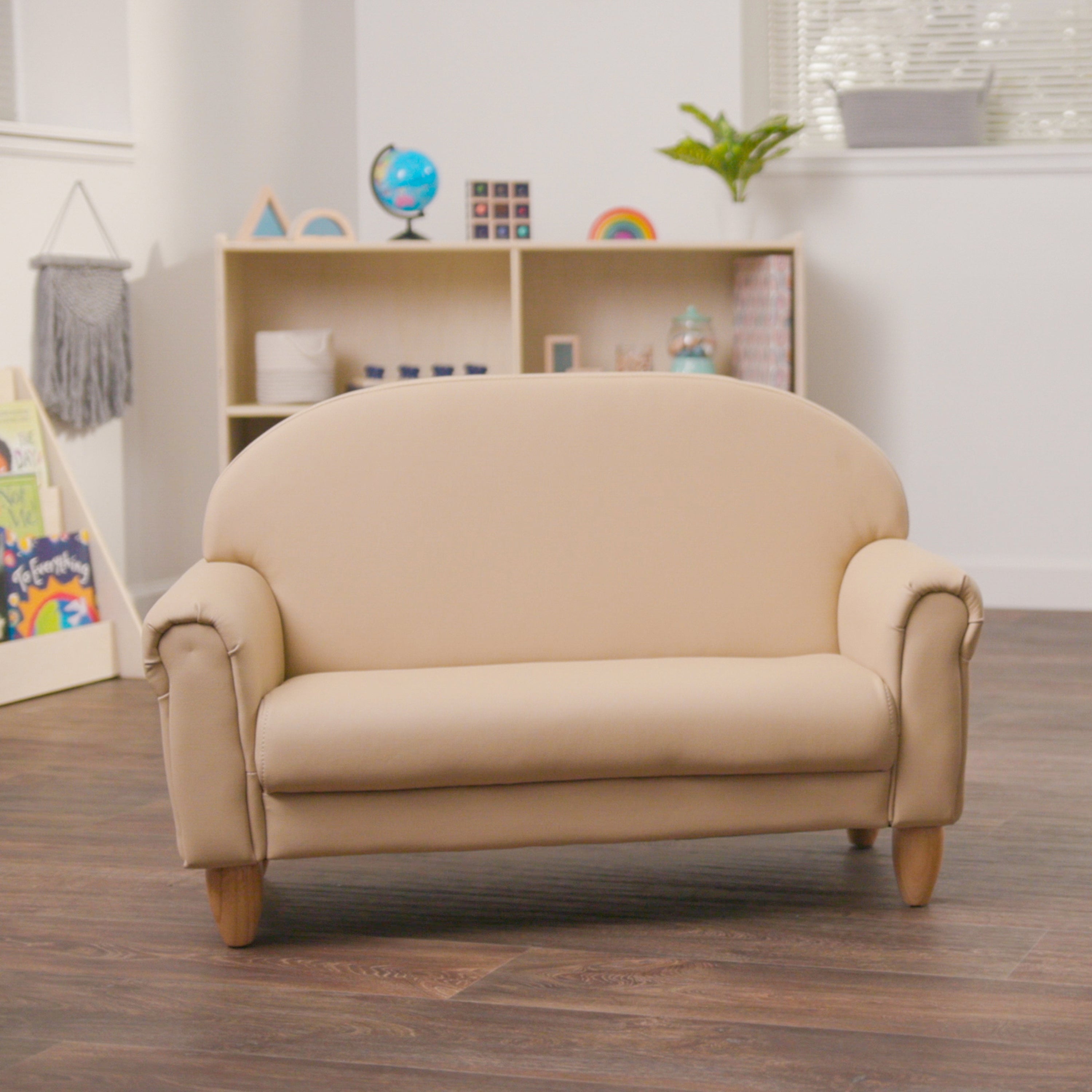 Beige sofa in a room with a bookshelf and decor items.
