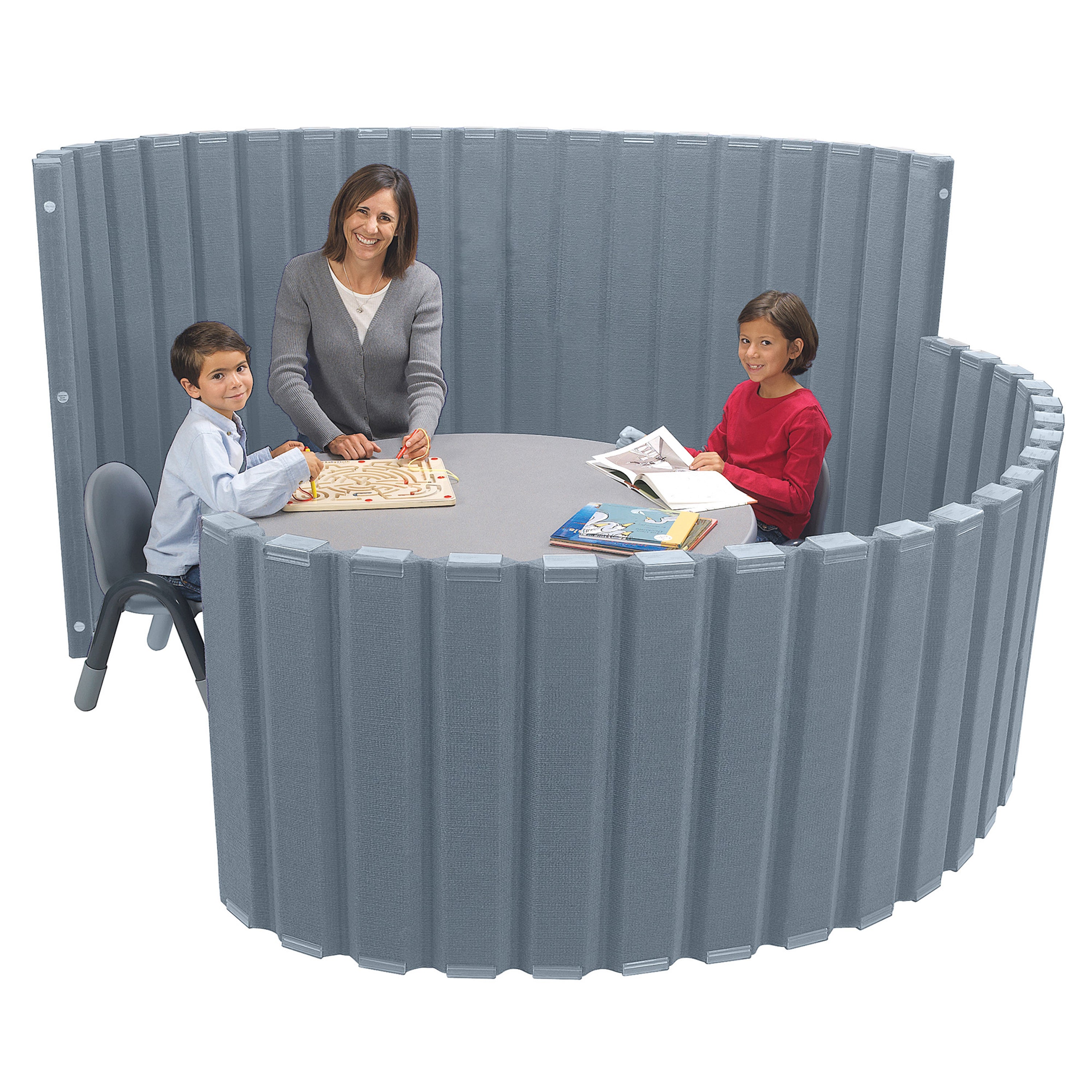 Children and a woman playing with educational materials at a round table enclosed by a gray modular wall.