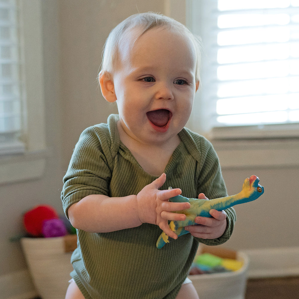 Toddler Holding Soft Squeezable Dinosaur Toy