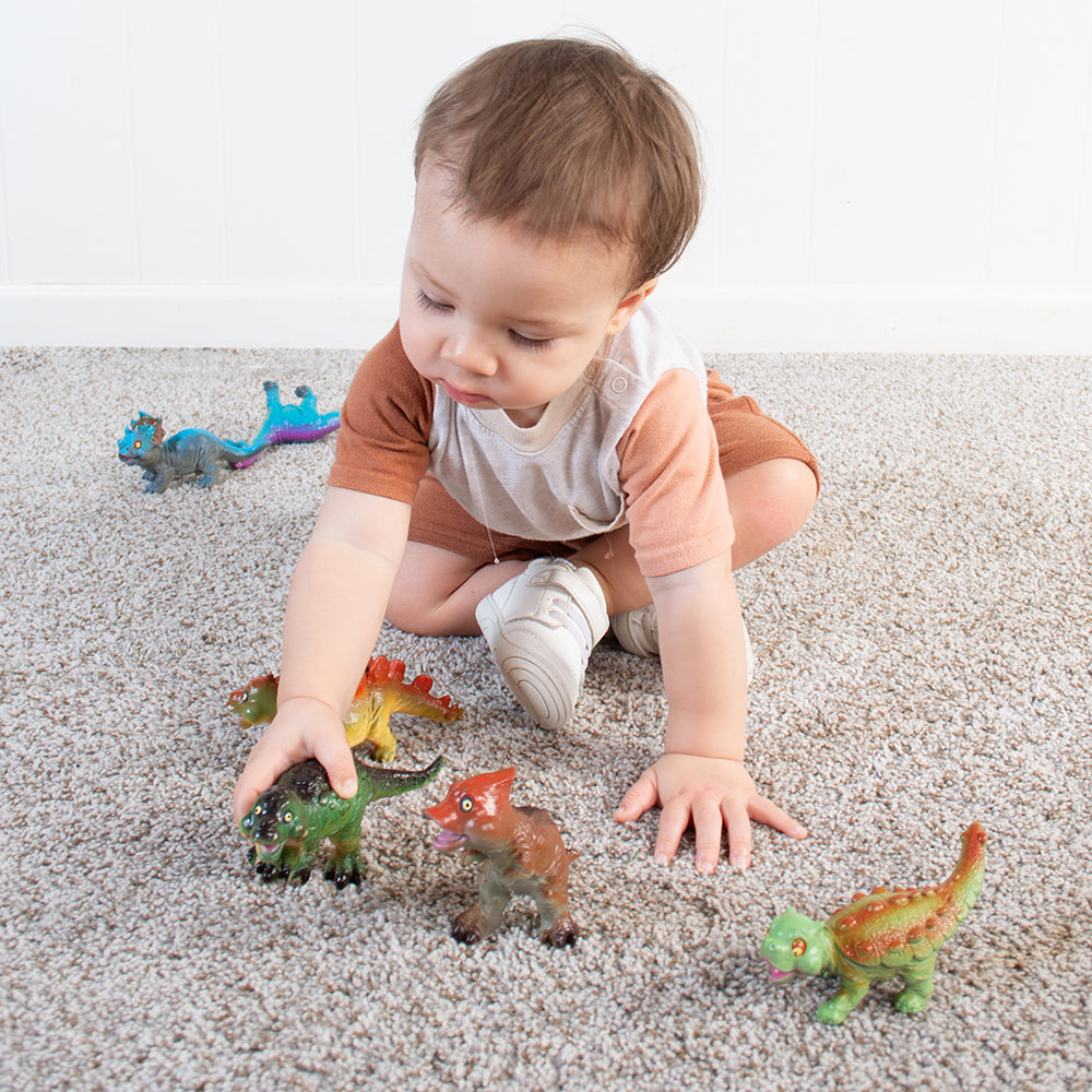 Toddler Interacting with Soft Squeezable Dinosaur Toys
