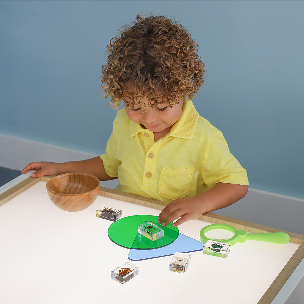 Child playing with educational toys on a lightbox