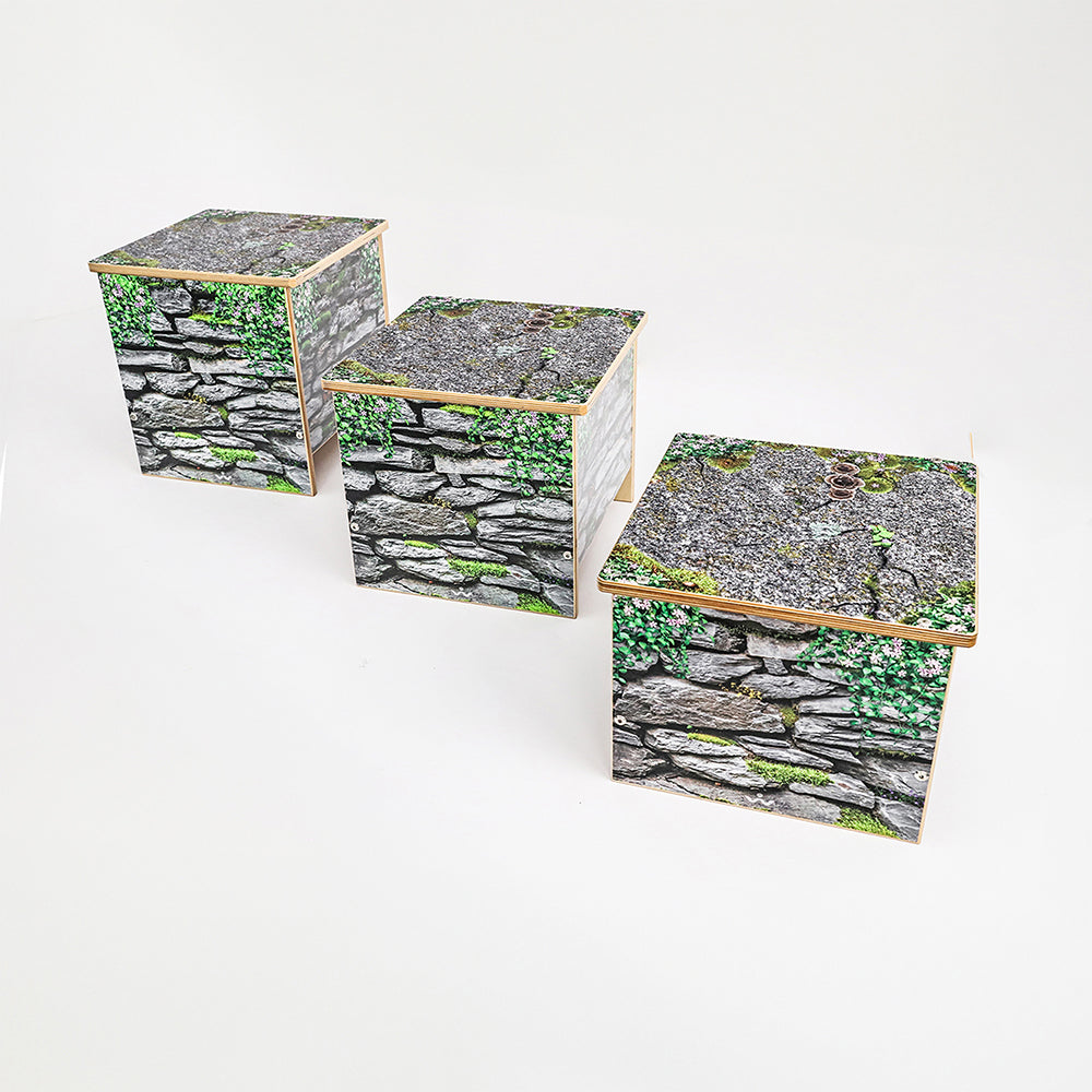 Three wooden benches in varying sizes with stone wall design on a white background