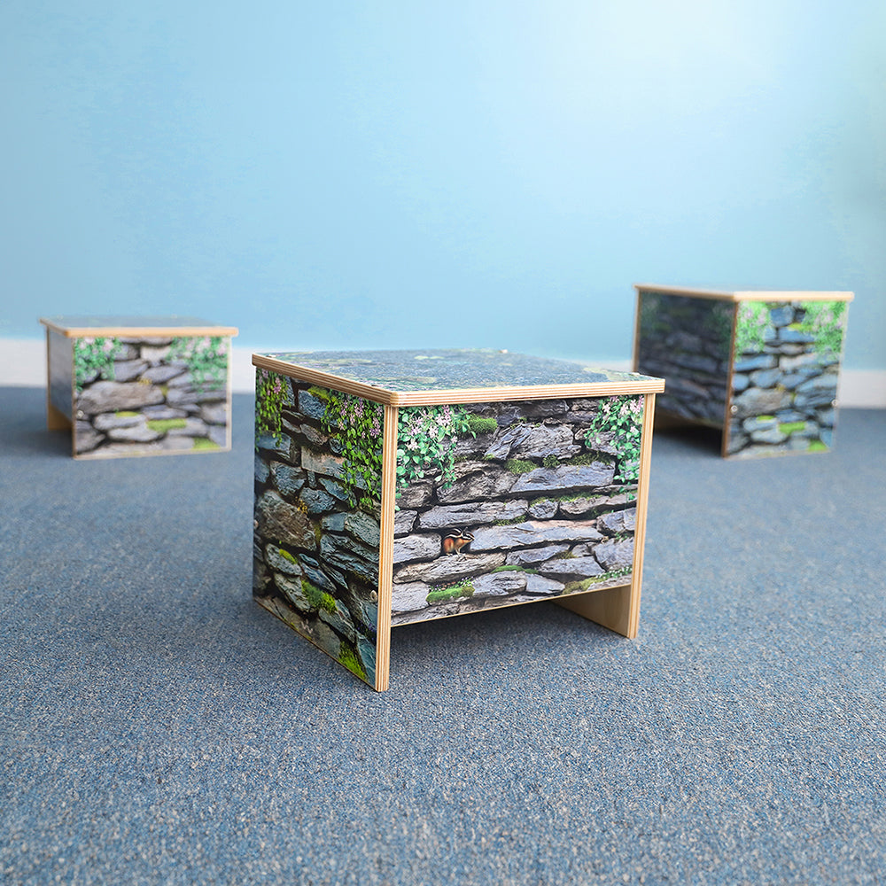 Three wooden benches with stone wall pattern on a blue surface and light blue background