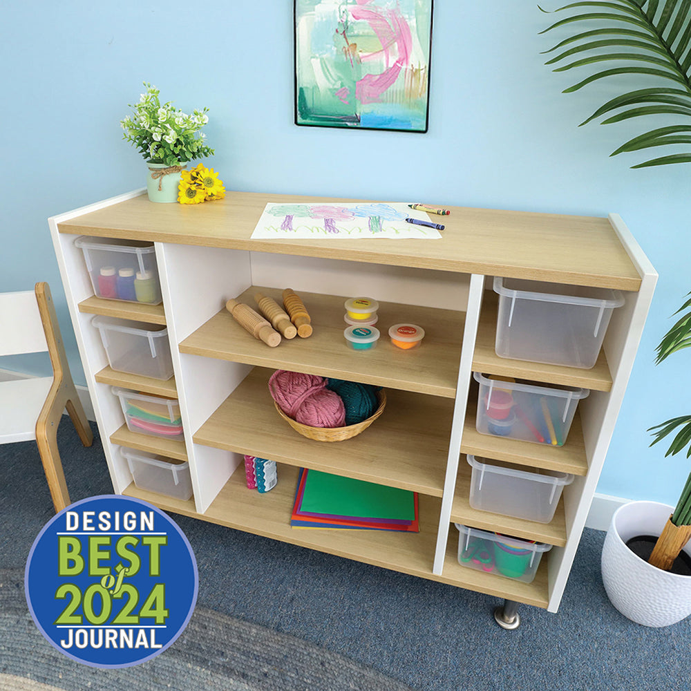 Wooden craft table with shelves and storage bins in a room with a blue wall and plants.