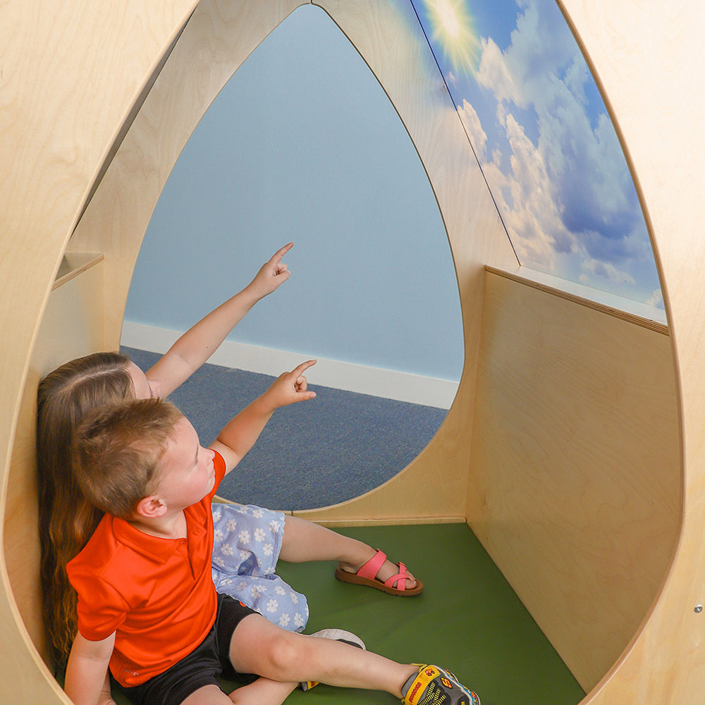Two children playing inside a wooden playhouse with a sky mural.