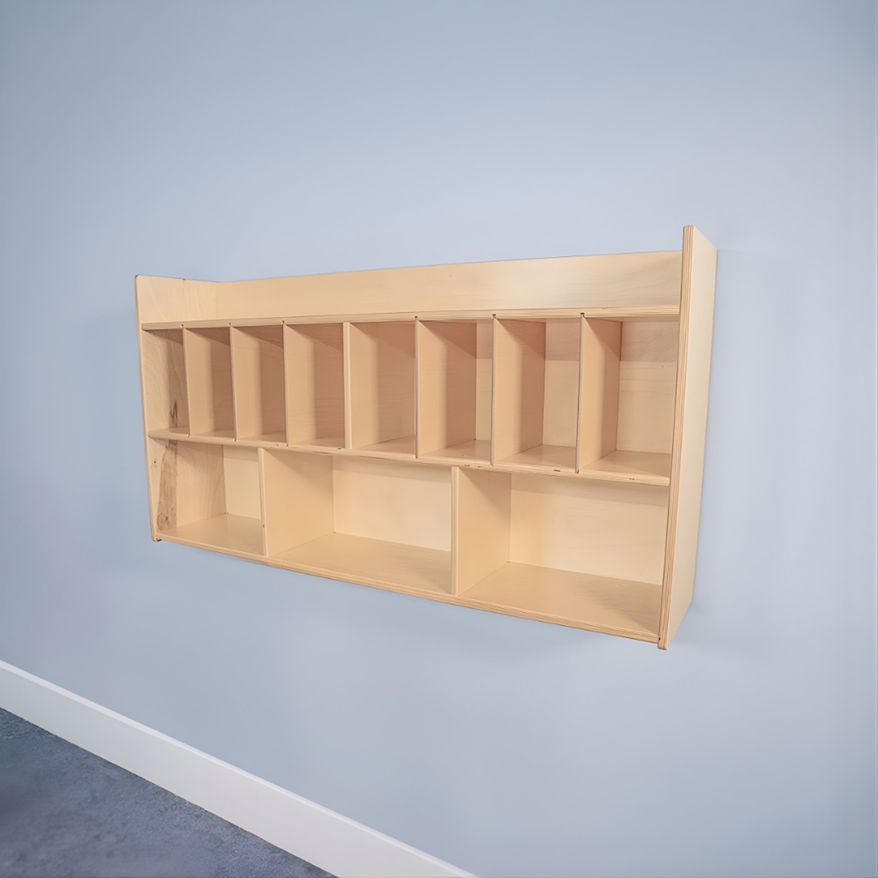 Wooden wall-mounted shelf with multiple compartments against a light blue wall.
