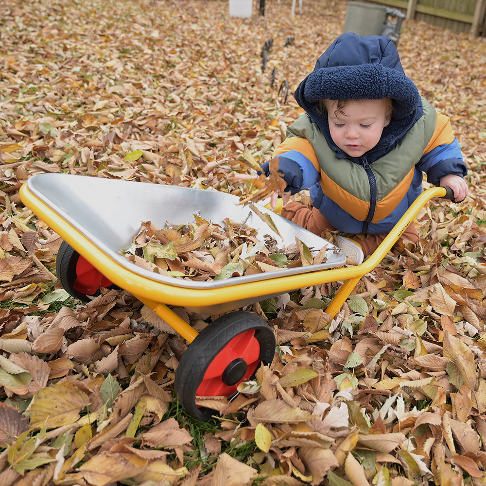 Toddler Playing with Wheelbarrow Outside