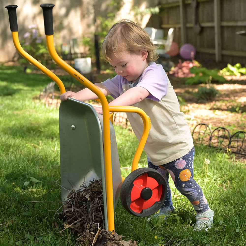 Kid Using Wheelbarrow to Dump Sticks & Twigs