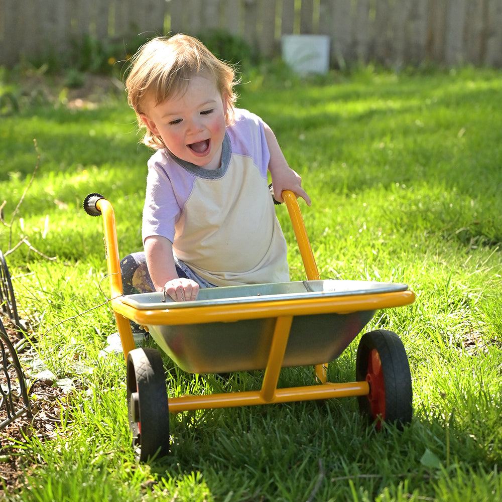 Toddler Having Fun with Wheelbarrow