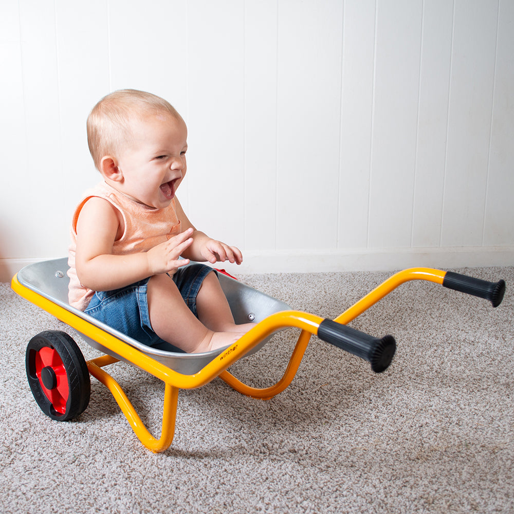 Toddler Sitting In Wheelbarrow