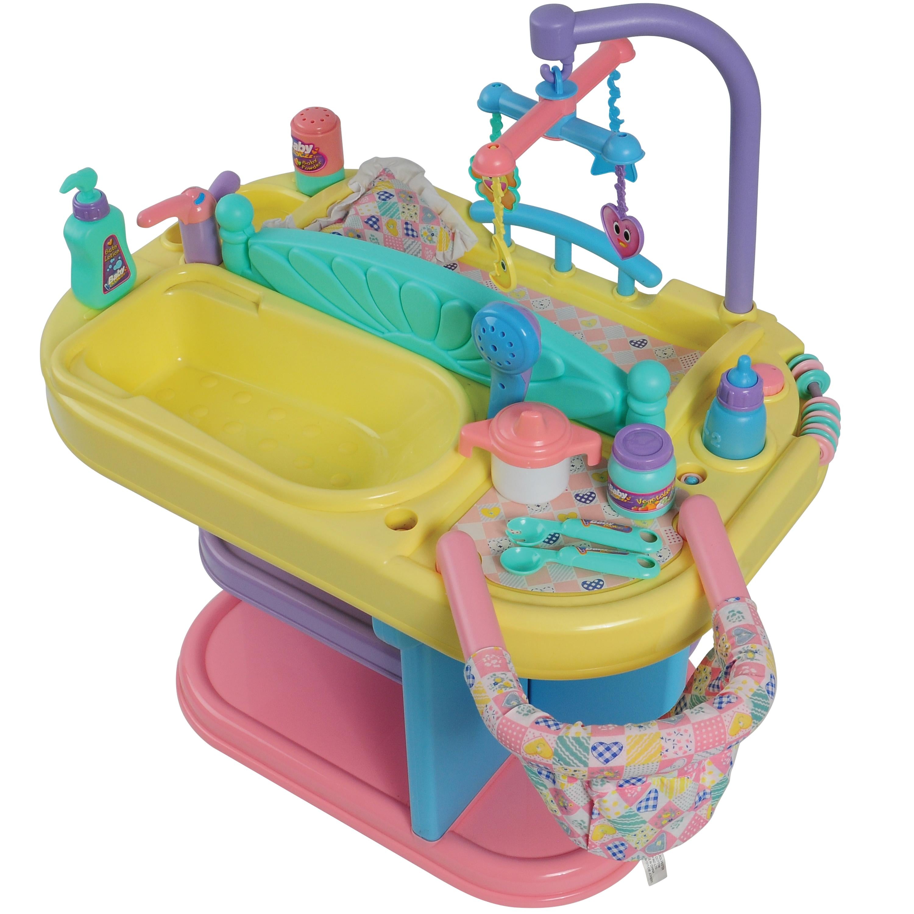 A colorful baby bath toy set with a yellow tub, pink base, teal shower attachment, hanging mobile, and matching bath accessories on a white background.