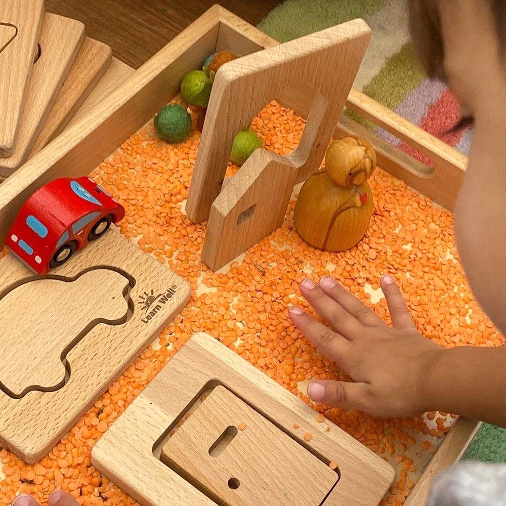 Toddler Using Little Looking Discovery Home-Themed Shapes with other sensory materials