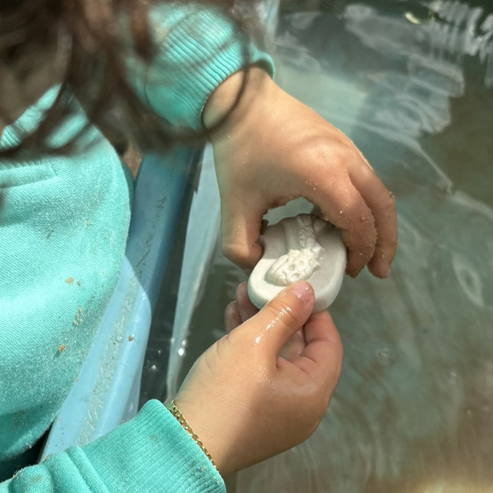 Kid Washing Fossil Pieces in Water