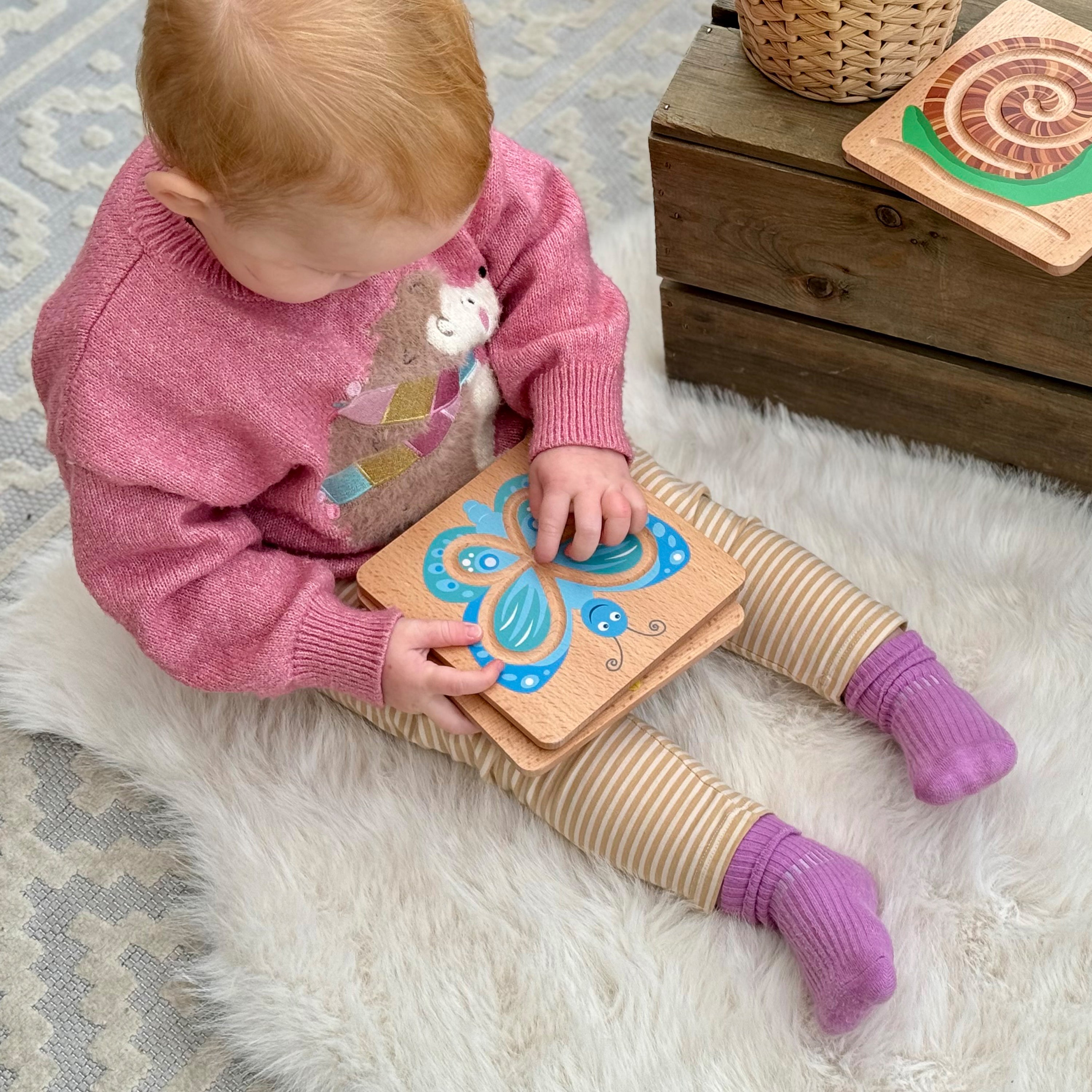 Child playing with a wooden toy on a soft surface