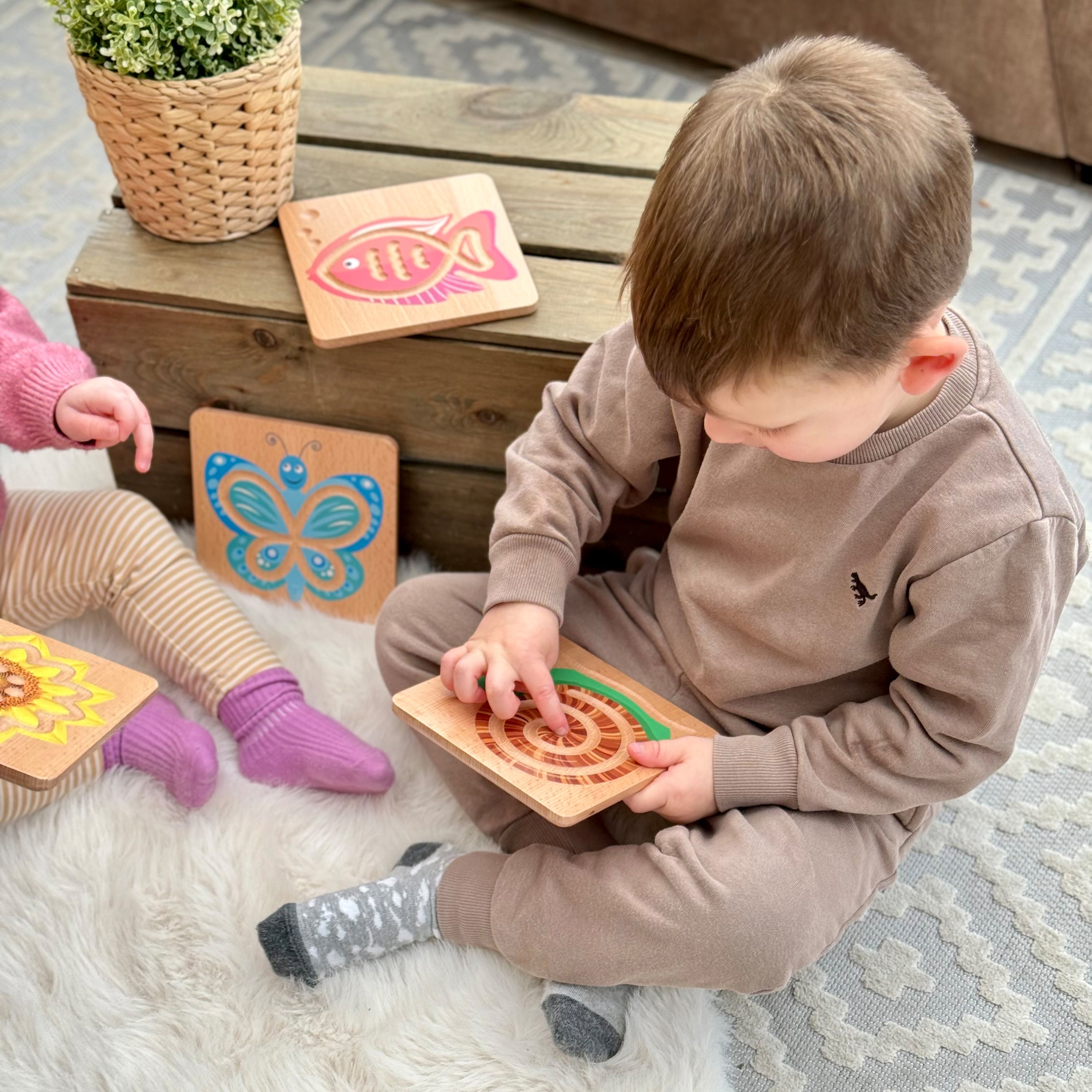 Two children playing with wooden toys on a rug