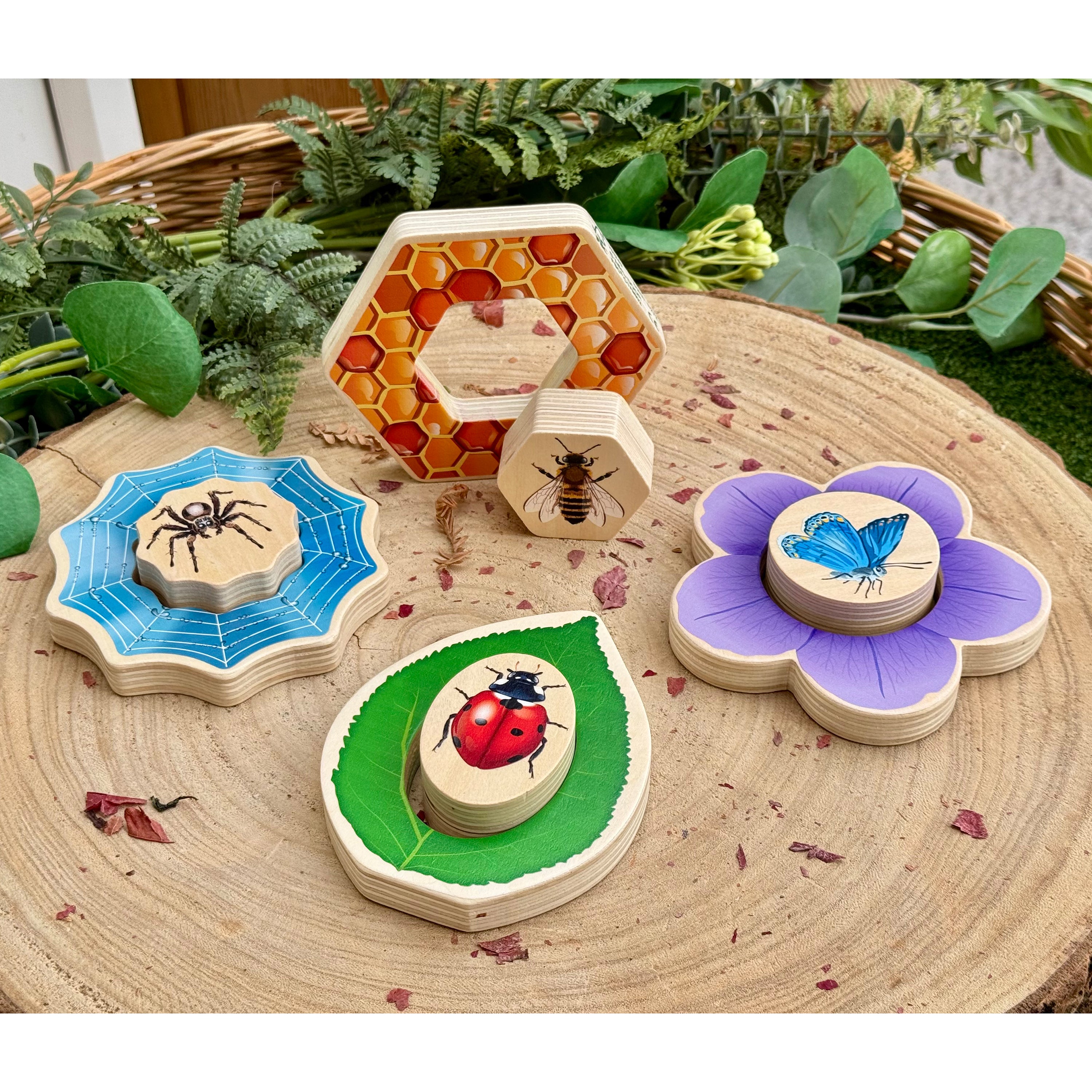 Set of wooden animal cards on a wooden surface with plants in the background