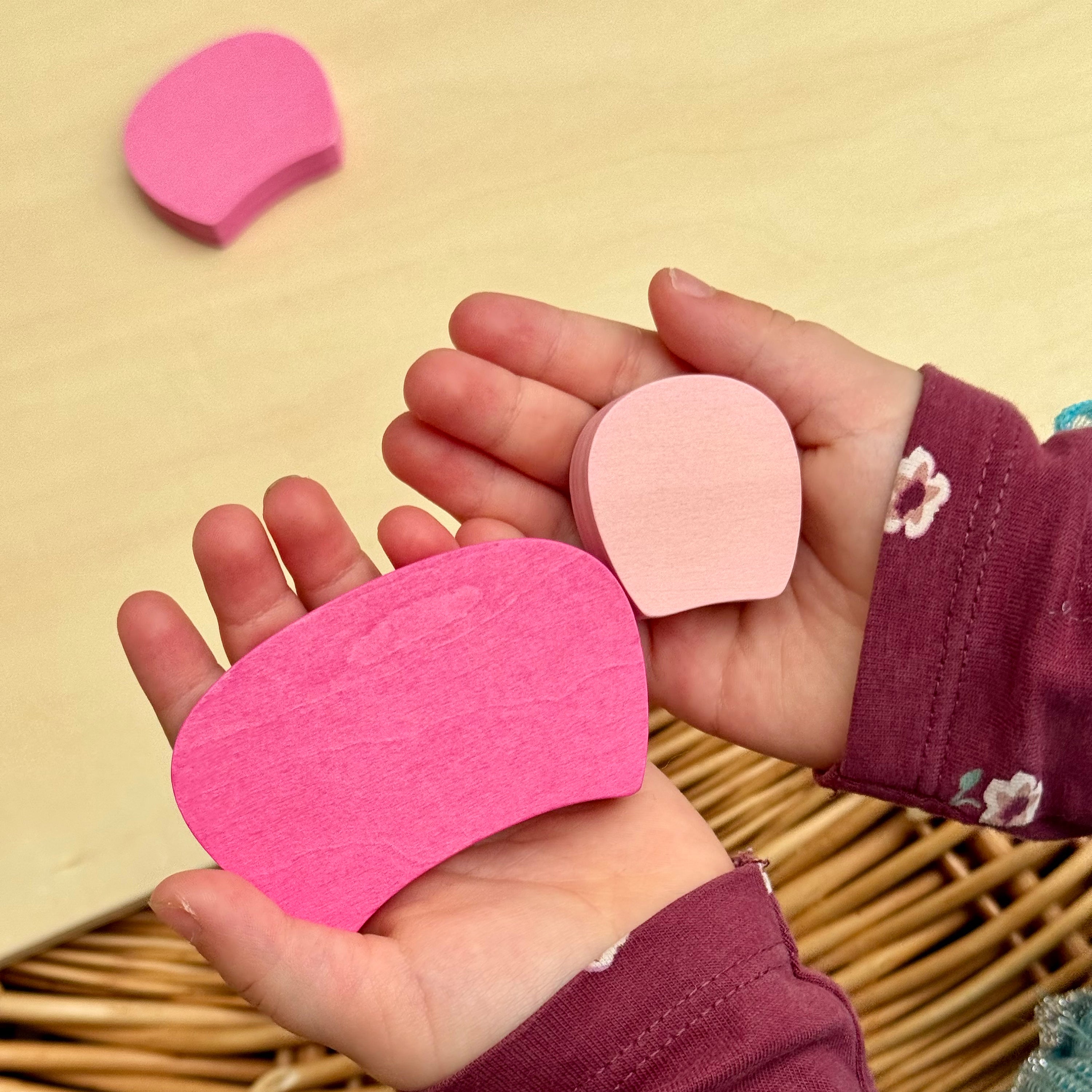 Pink puzzle pieces held in a child's hands against a beige background