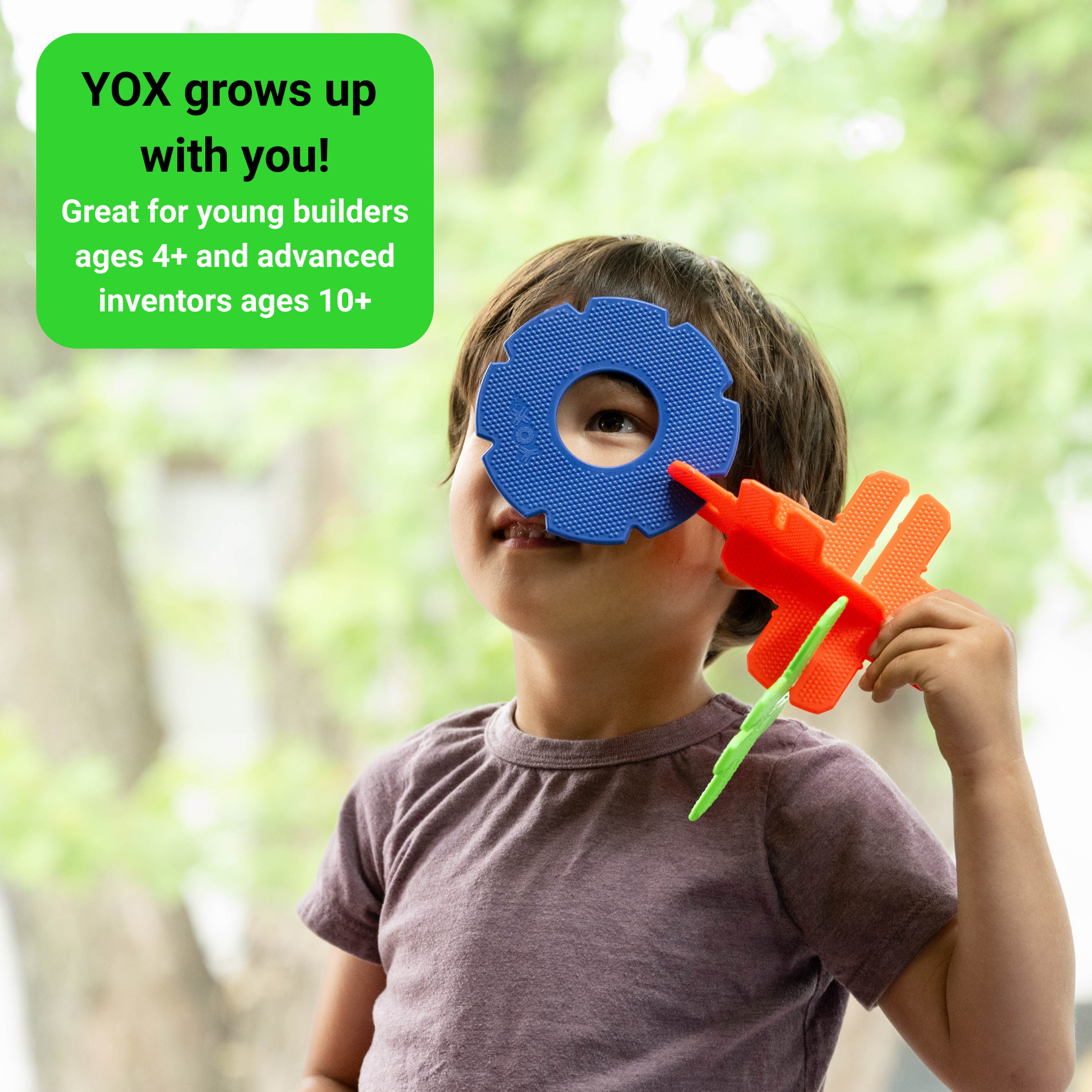 Child holding a blue and orange toy with text about 'YOX' product.