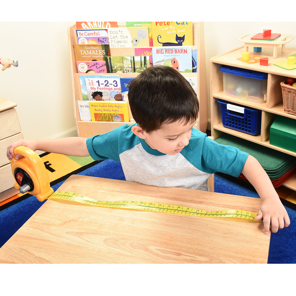 Kid Measuring A Desk in Classroom