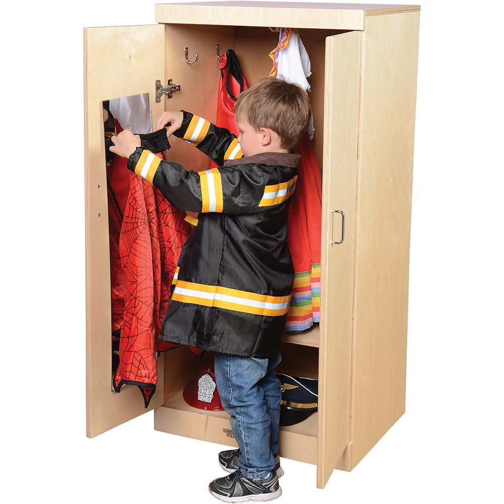 Kid Inspecting Cape In Front of Child-Sized Wooden Dress Up Cupboard with Mirror, Hooks & Storage