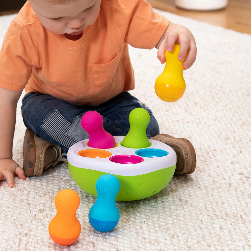 Toddler with Spinny Pins on beige carpet