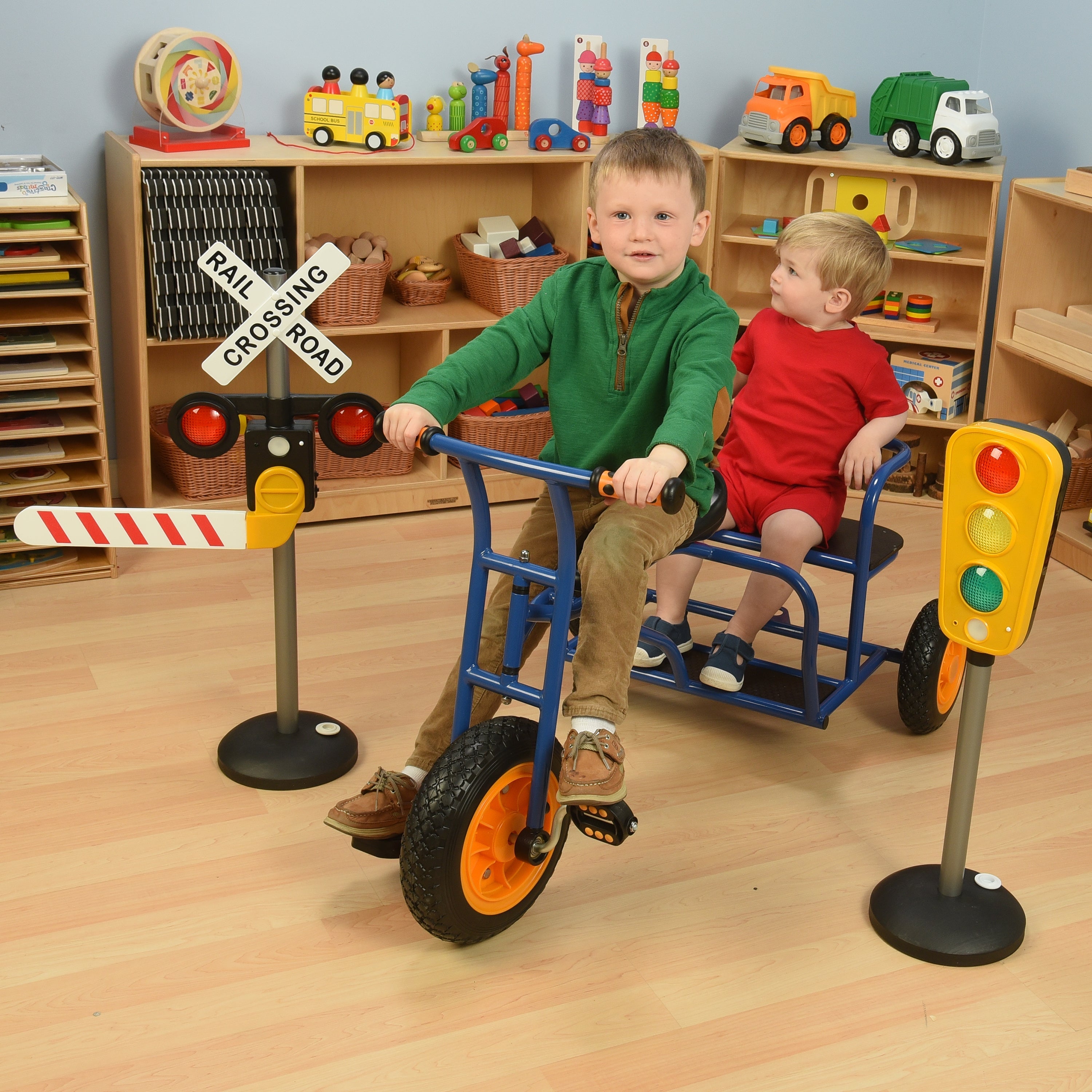 Two kids on Taxi Trike in classroom environment