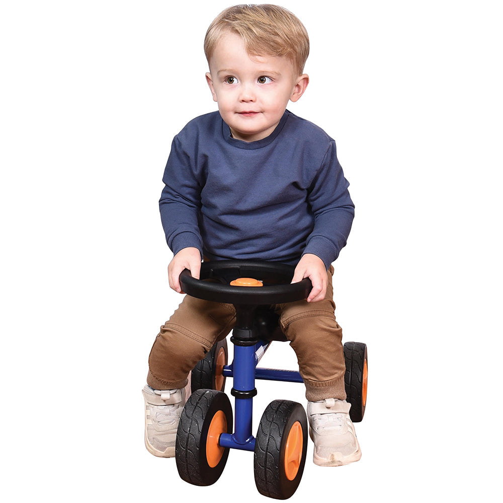 Toddler in blue shirt seated on blue trike with white background