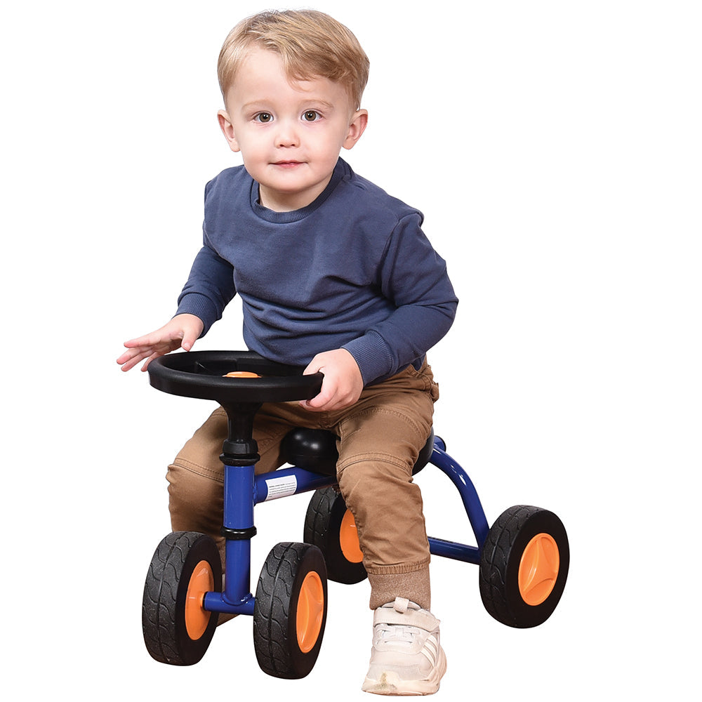 Toddler in blue shirt seated on blue trike with white background
