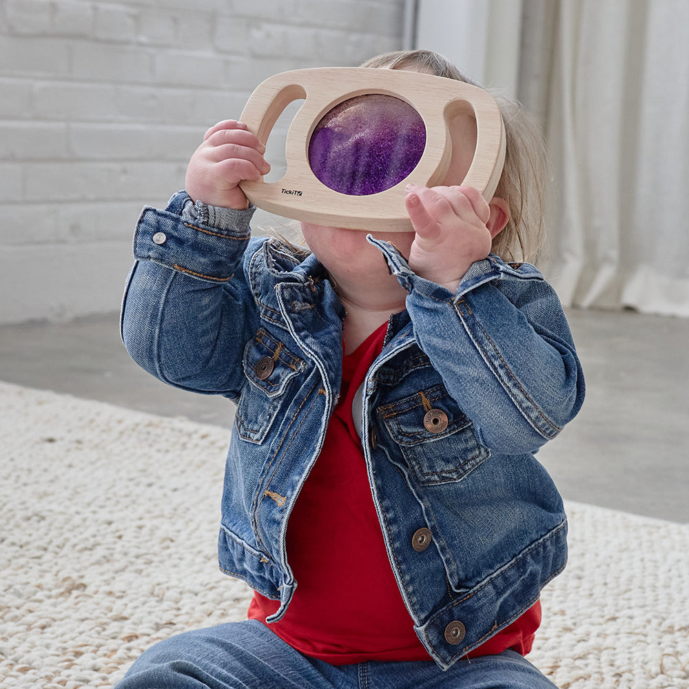 Child Looking Through Glitter Panel