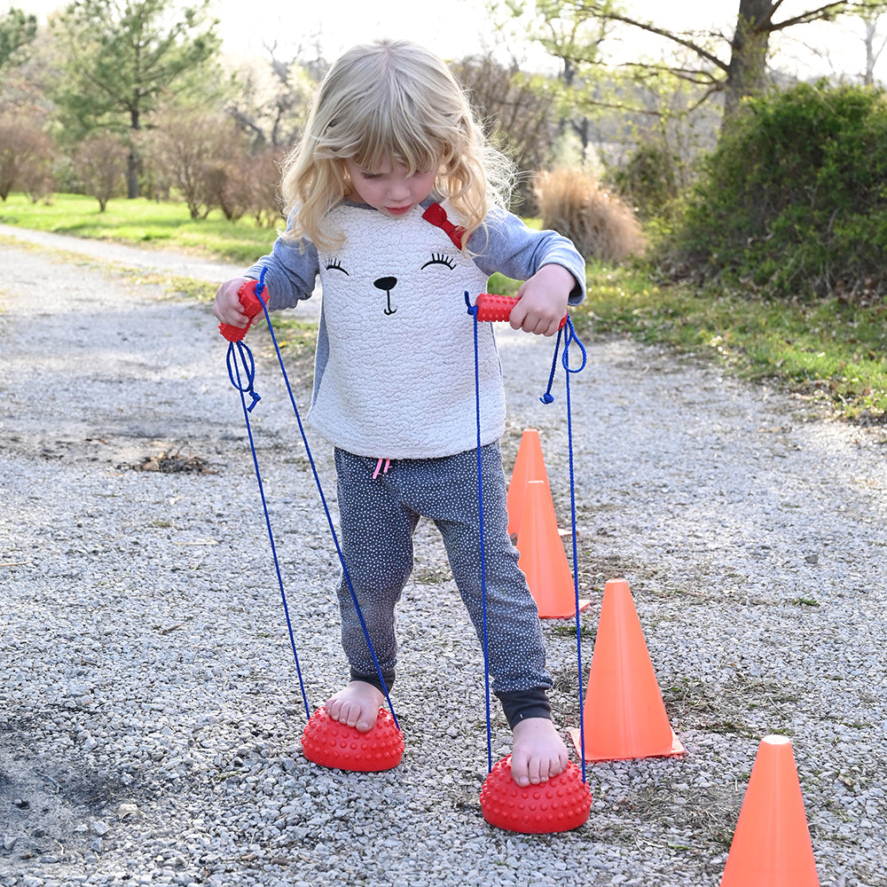 Kid Using Tactile Half-Sphere Stilts Outdoors