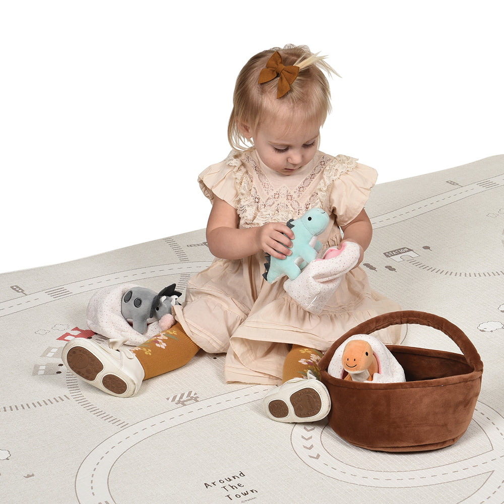 Toddler Examining Plush Basket of Dinosaurs